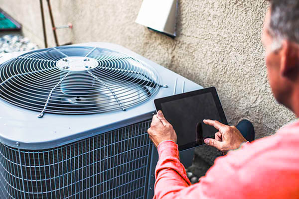 Maintenance engineer using digital tablet to inspect air conditioning unit Maintenance engineer using digital tablet to inspect air conditioning unit